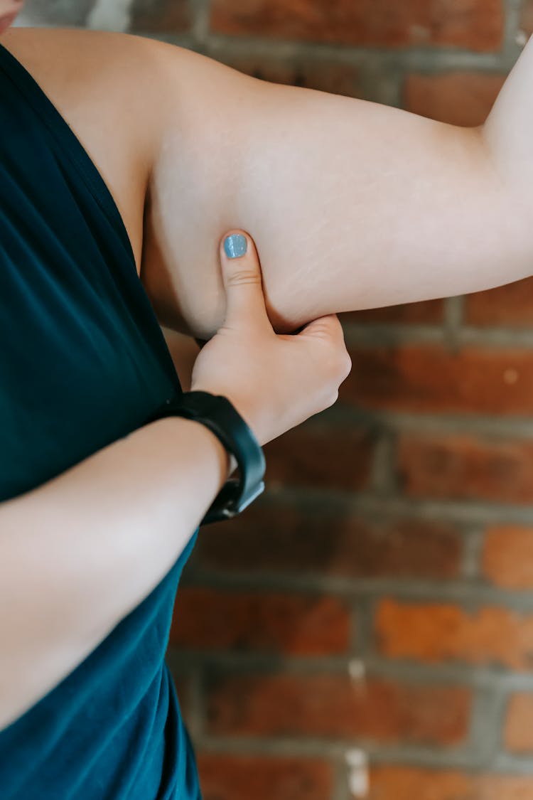 Overweight Woman Touching Arm In Gym