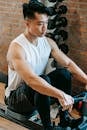 Young handsome Asian man training with gym equipment