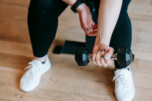 Free Unrecognizable woman training with dumbbell in sport club Stock Photo