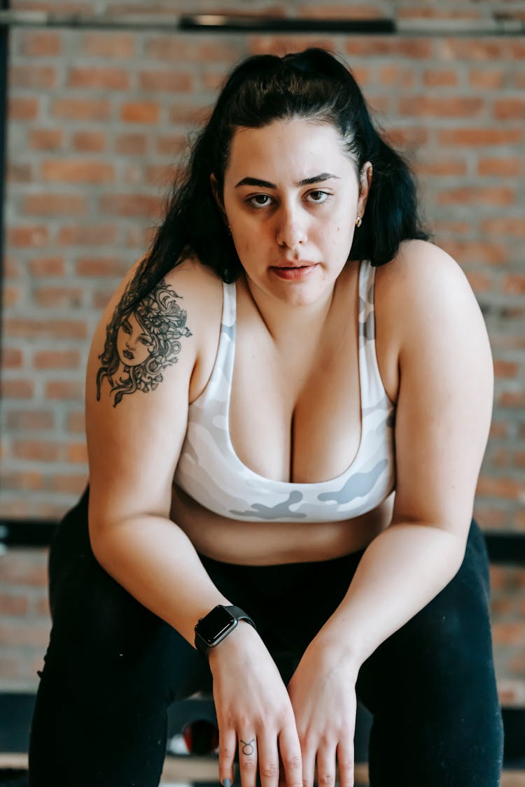 Calm Young Obese Woman Relaxing On Bench After Training In Gym