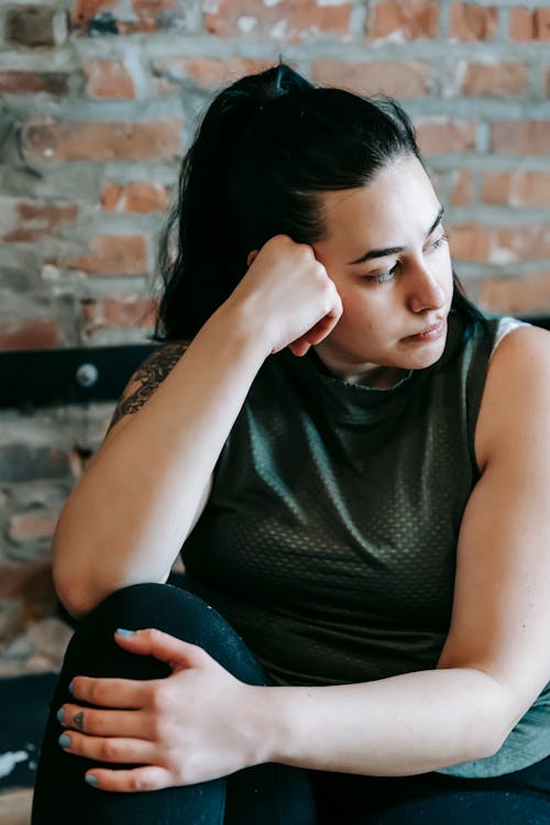 Thoughtful woman resting in sports hall