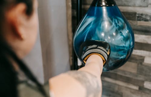 Woman punching heavy boxing bag during training