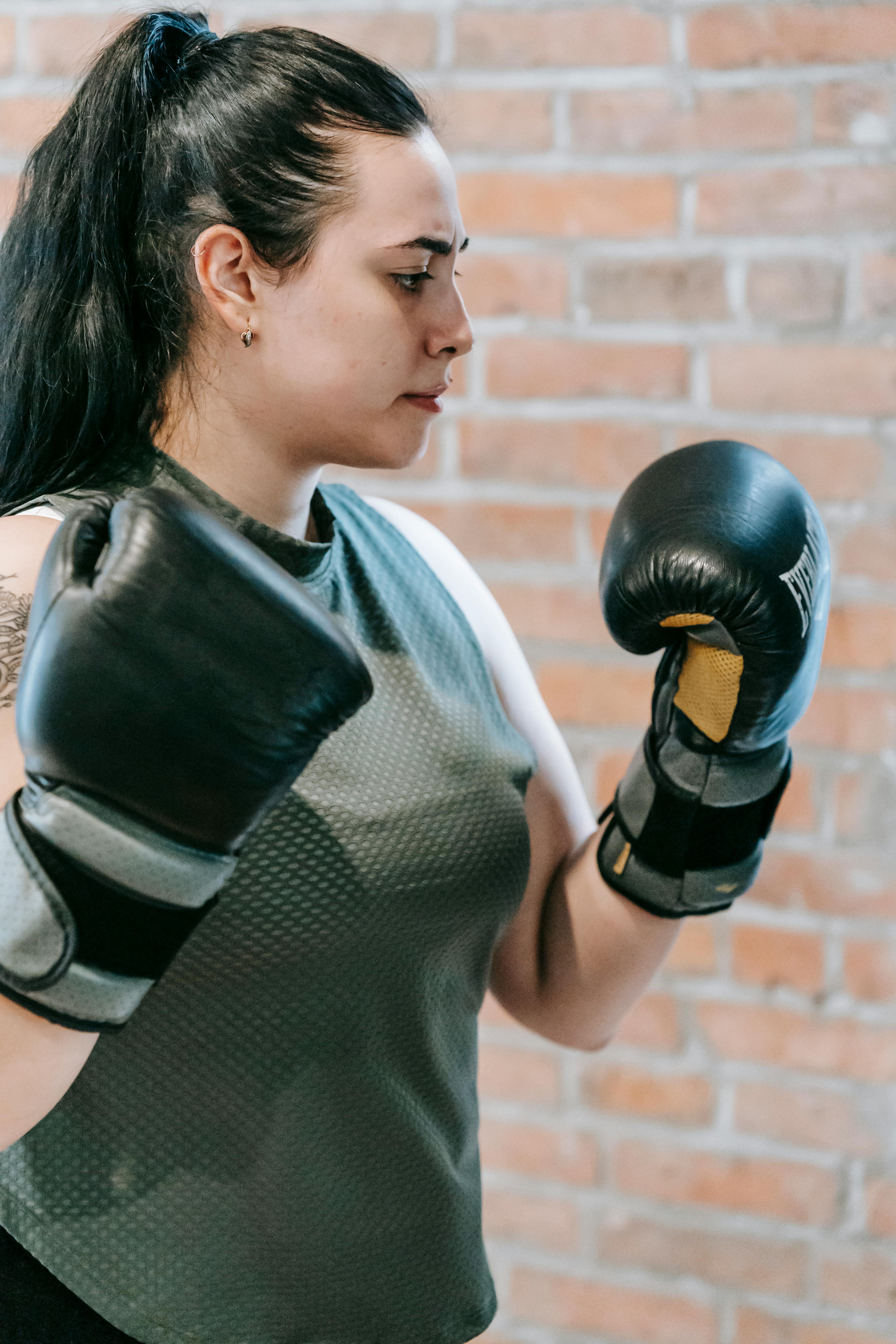 confident female in boxing gloves preparing for punch