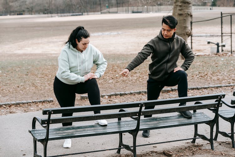 Asian Trainer Teaching Woman Doing Sports Exercise In Park