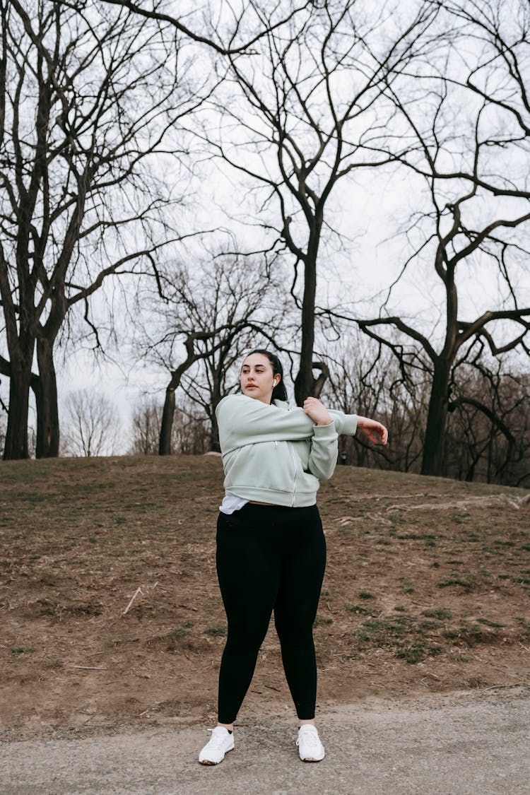 A Young Woman Training In A Park