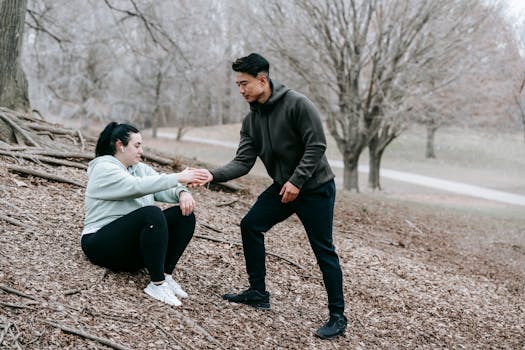 Full body of diverse man and woman resting after training in park with autumn dry leaves