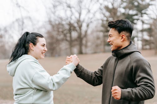 Free Young positive Asian trainer supporting and giving hand to woman Stock Photo