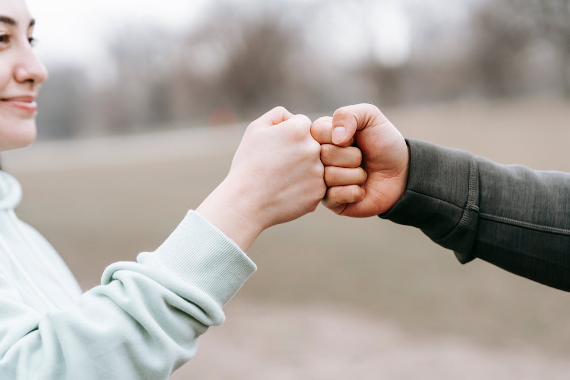 https://www.pexels.com/photo/man-and-happy-woman-greeting-each-other-with-fist-bump-6551298/