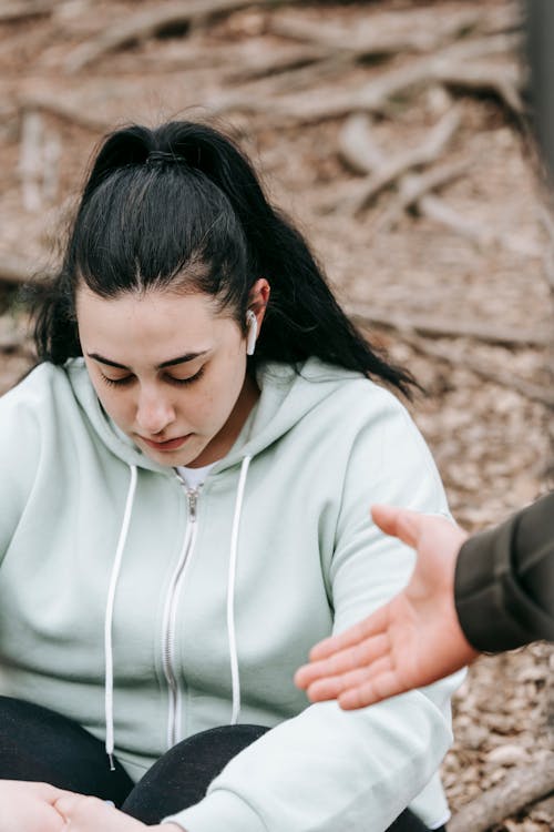 Tired plus sized female sitting on ground and looking down