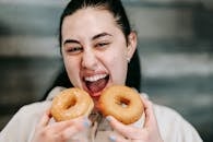 Hungry woman with delicious donuts at home
