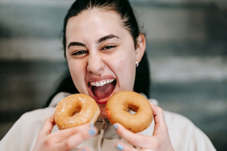 Hungry Woman With Delicious Donuts At Home