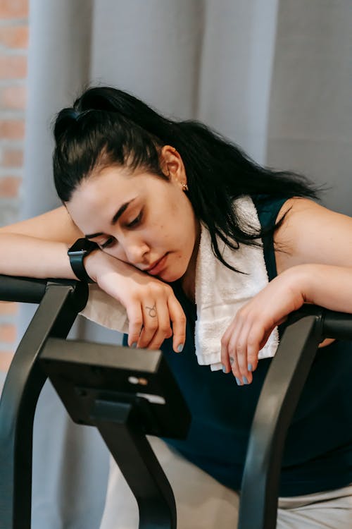 Free Exhausted young woman on exercise machine Stock Photo