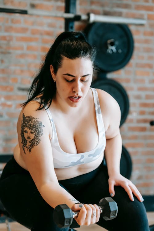 Wanita Muda Berolahraga Dengan Dumbbell Di Gym