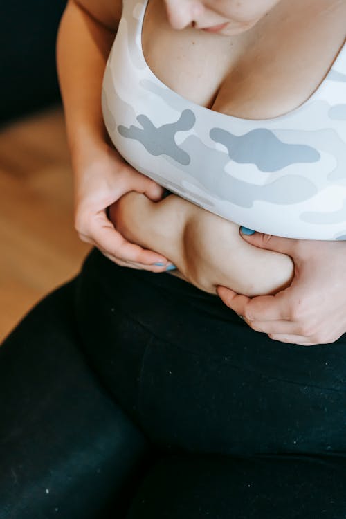 Anonymous overweight woman touching tummy during training