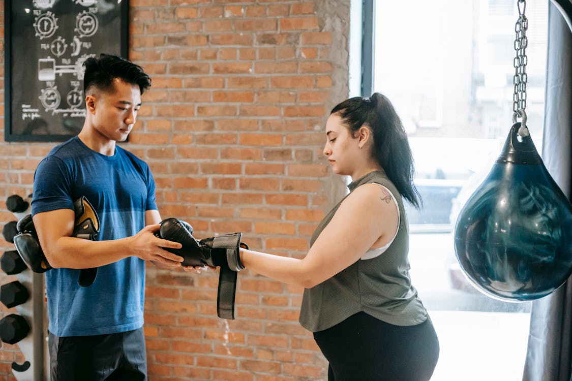Free Overweight female training with trainer in boxing club Stock Photo