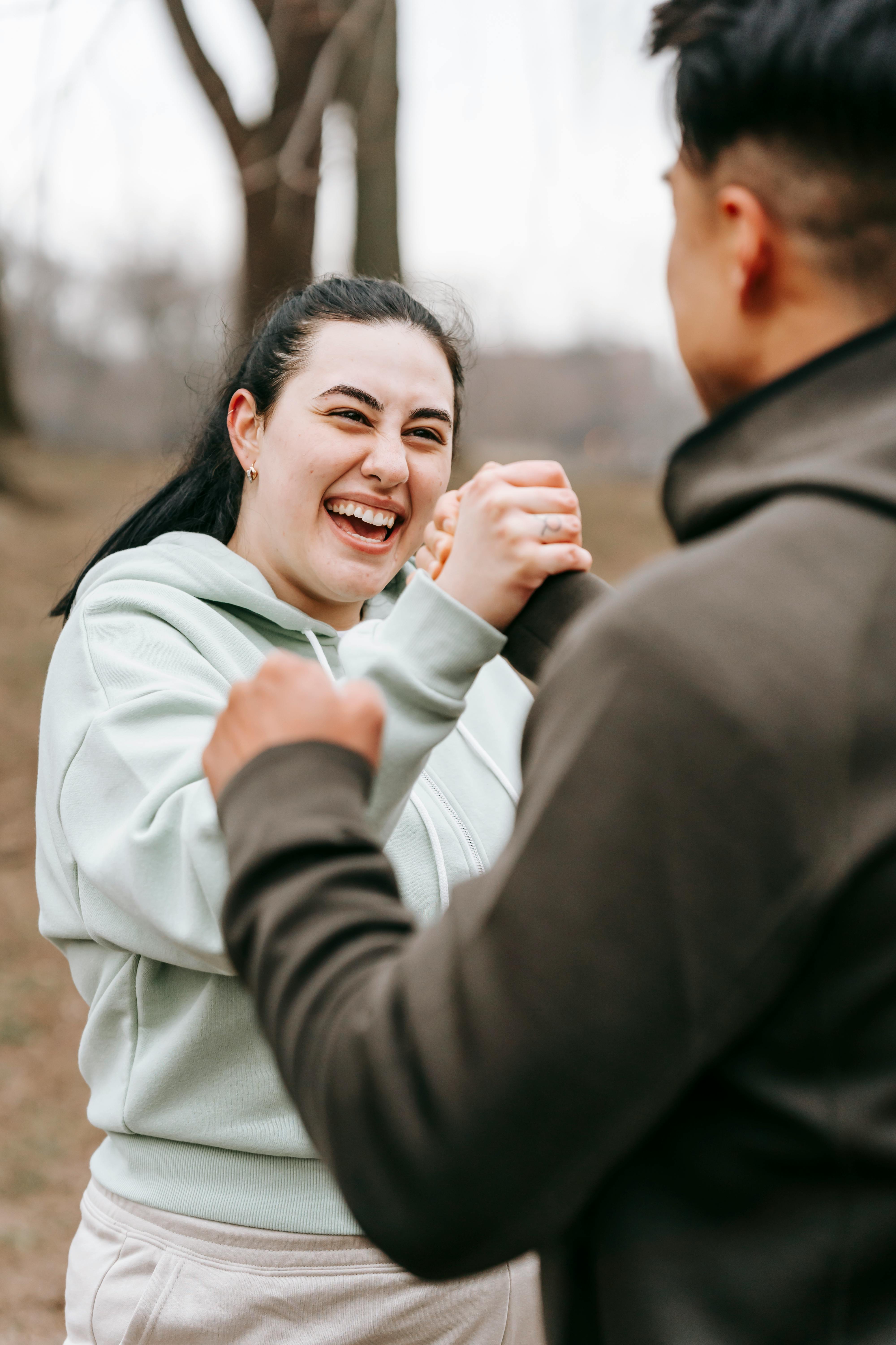 joyful friends shaking hands in autumn park