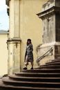 Man in Black and White Plaid Dress Shirt Standing on Brown Staircase