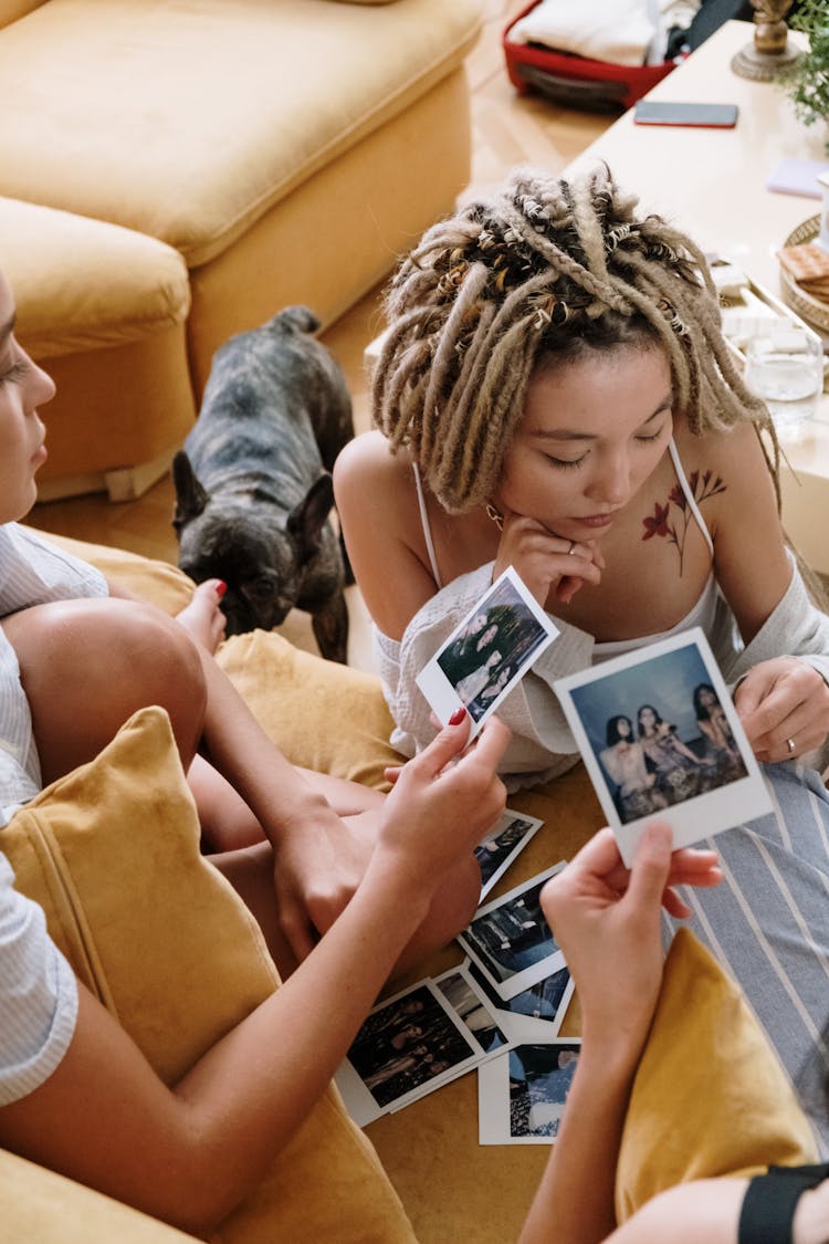 Women In Pajamas Holding Polaroid Pictures