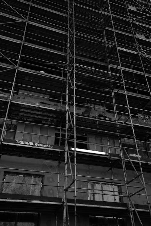 Grayscale Photo of Scaffolding Outside a Building