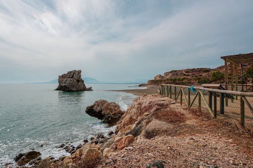 A Rock Formations on the Beach Under the Cloudy Sky