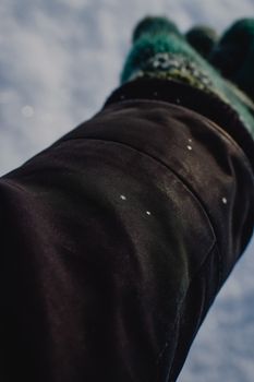 Detailed view of snowflakes on a winter glove sleeve, capturing the essence of winter in Estonia.