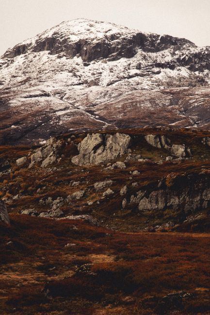 Breathtaking view of a Norwegian mountain with snowy peaks and rocky terrain in autumn.