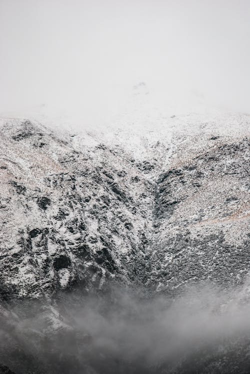 Snowy mountain ridge against misty sky