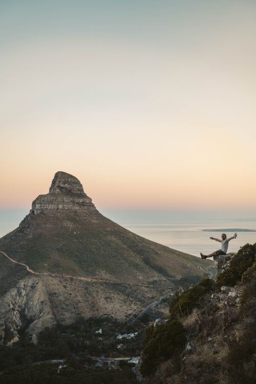 Free Silhouette of a hiker celebrating at sunset near Lion's Head in Cape Town. Stock Photo