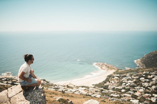 A Man on a Rocky Cliff with a Scenic View