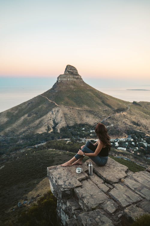 A Woman on a Rocky Cliff with a Scenic View