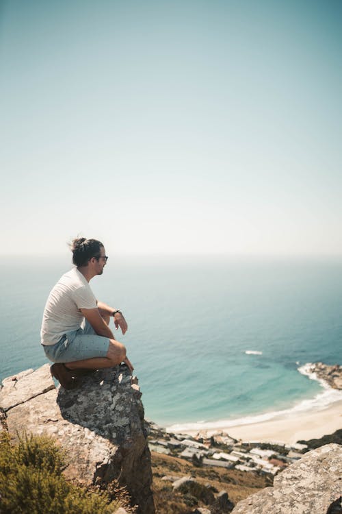 A Man on a Rocky Cliff with a Scenic View