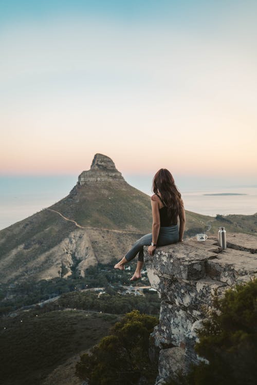 A Woman on a Rocky Cliff with a Scenic View