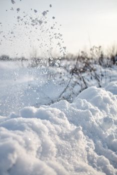 Close-up of fresh snow and flying snowflakes in an Estonian winter field.