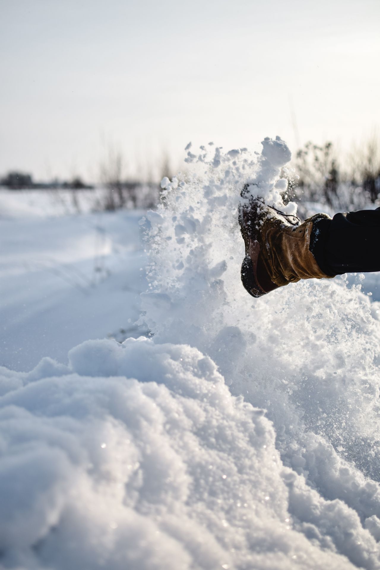 Winter boot kicking up fresh powder snow
