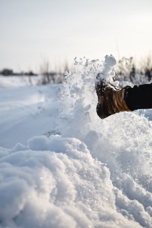 Free A close-up of boots kicking up snow in an Estonian winter landscape. Stock Photo