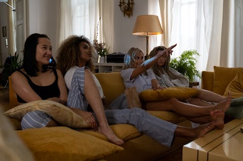 Free Women in Pajamas Sitting on the Sofa Stock Photo