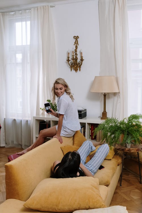 Free Women in Pajamas Sitting on the Sofa Stock Photo