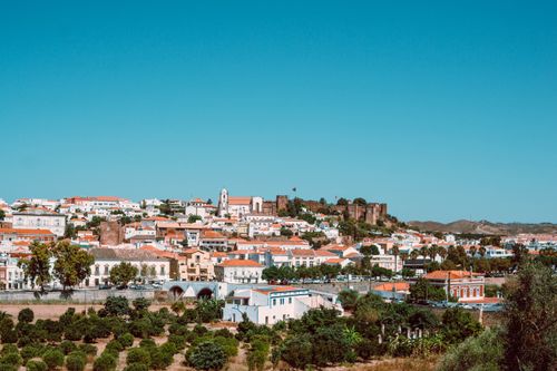 Free Beautiful panoramic view of Silves in Portugal showcasing historic buildings and Silves Castle under a clear blue sky. Stock Photo