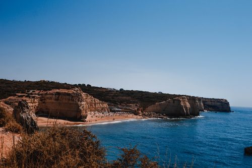 Free Stunning view of Carvoeiro's cliffs and tranquil beach along the Algarve coast in Portugal. Stock Photo