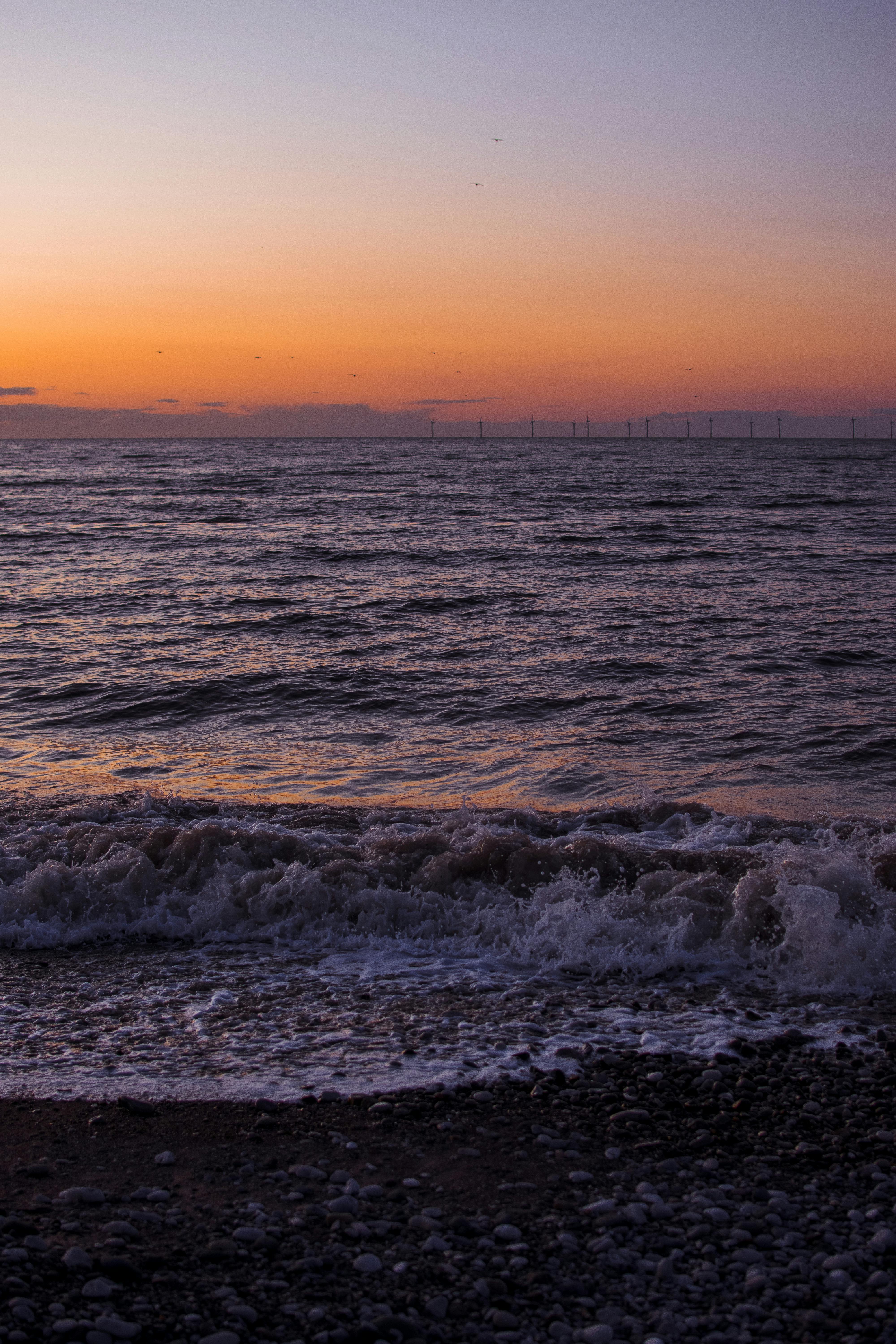 日落时平静的海浪，海洋上的橙色天空，非常适合宁静的环境