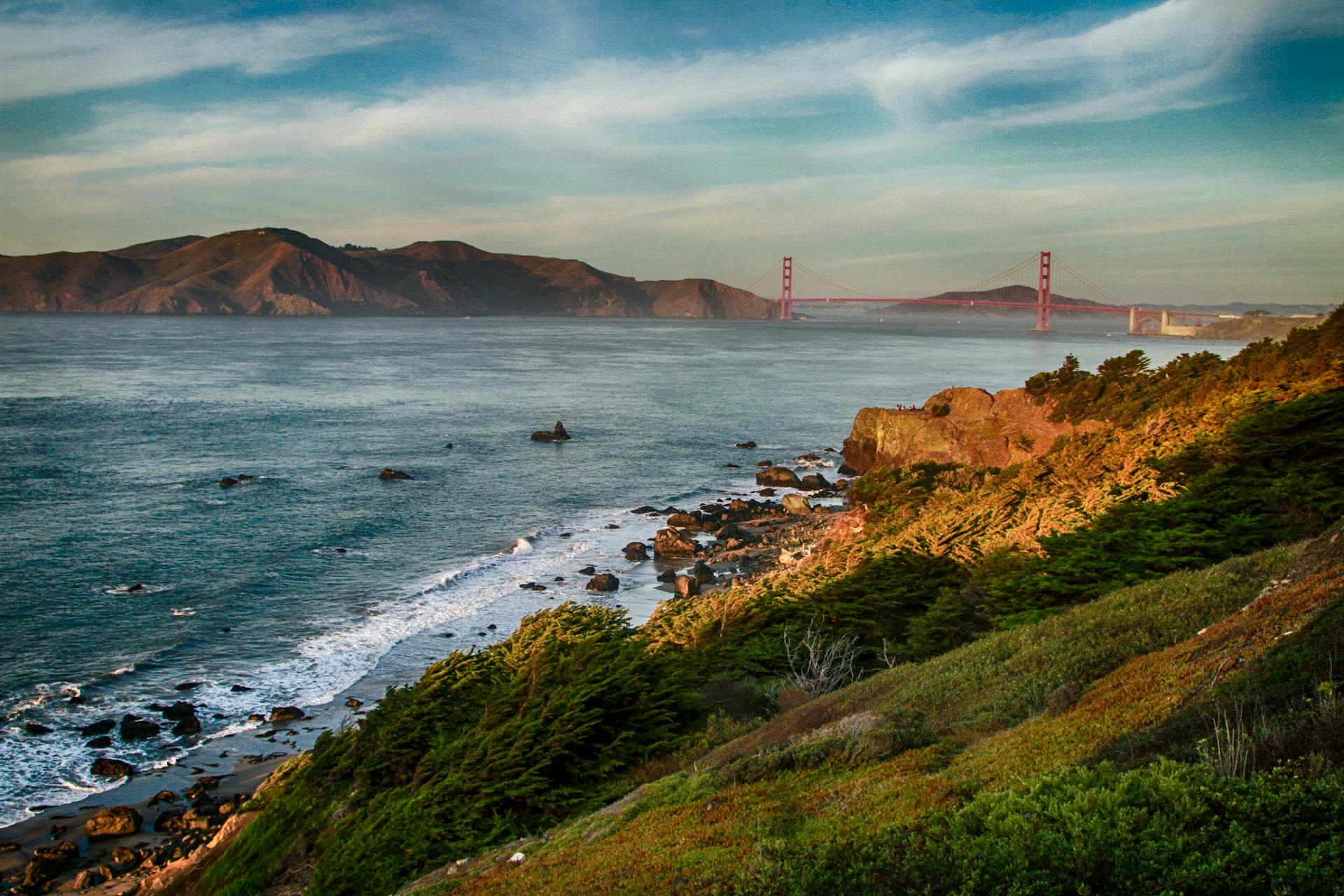 Scenic view of the Golden Gate Bridge over the San Francisco coastline under a blue sky.