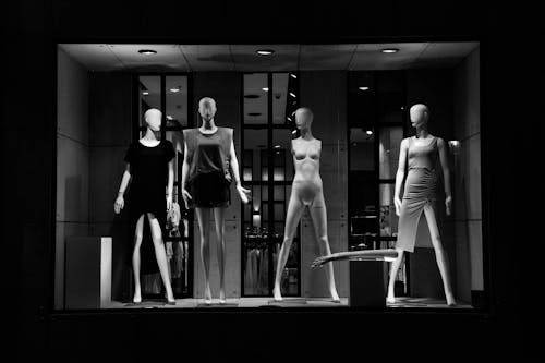 Grayscale Photo of Mannequins on Display Window