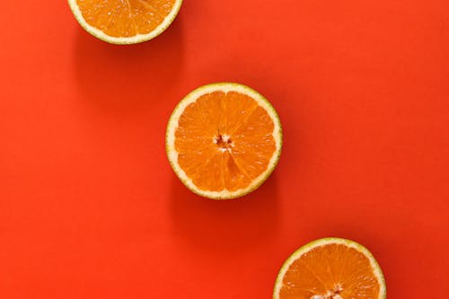 Sliced Orange Fruit on Red Surface