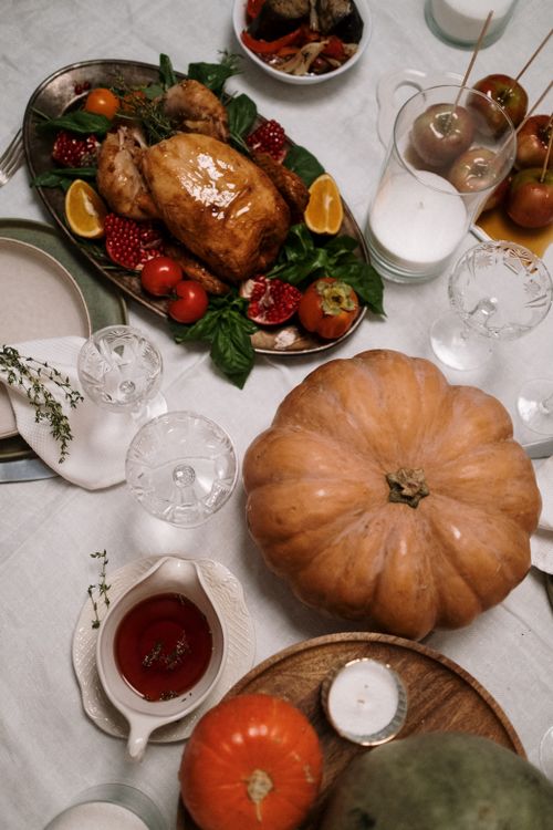 Free Elegant Thanksgiving table setting with roasted turkey and seasonal decorations. Stock Photo