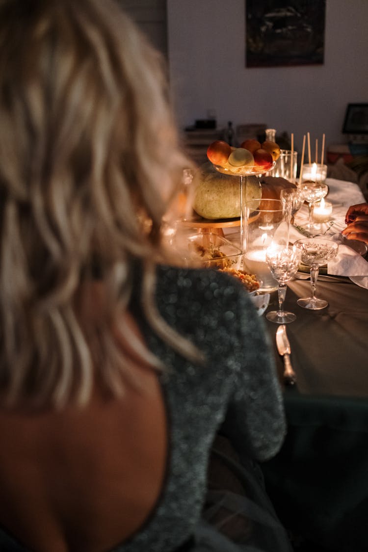 Woman Wearing A Backless Dress Sitting At The Dinner Table