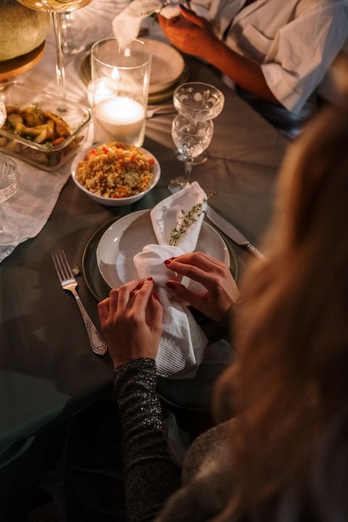 Free An intimate candlelit dinner setup with elegant tableware and delicious dishes, perfect for holiday celebrations. Stock Photo