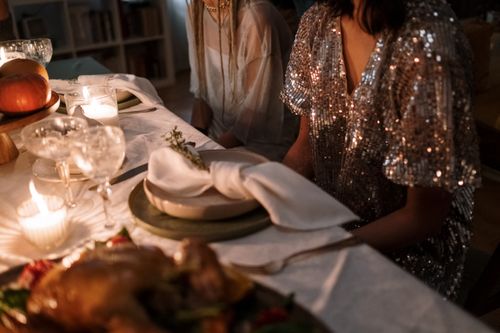 Free A warm and elegant candlelit dinner setting with guests enjoying a festive meal. Stock Photo