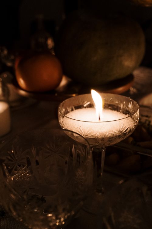 Free A warm, intimate candlelit dinner table setting featuring glassware and food. Stock Photo