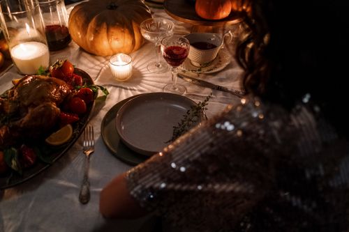 Free Intimate Thanksgiving dinner setup with candles, turkey, and elegant table setting. Stock Photo