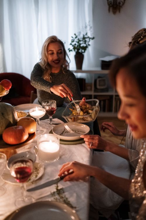 Free Warm indoor dinner setting with friends enjoying a cozy celebration around a beautifully set table. Stock Photo